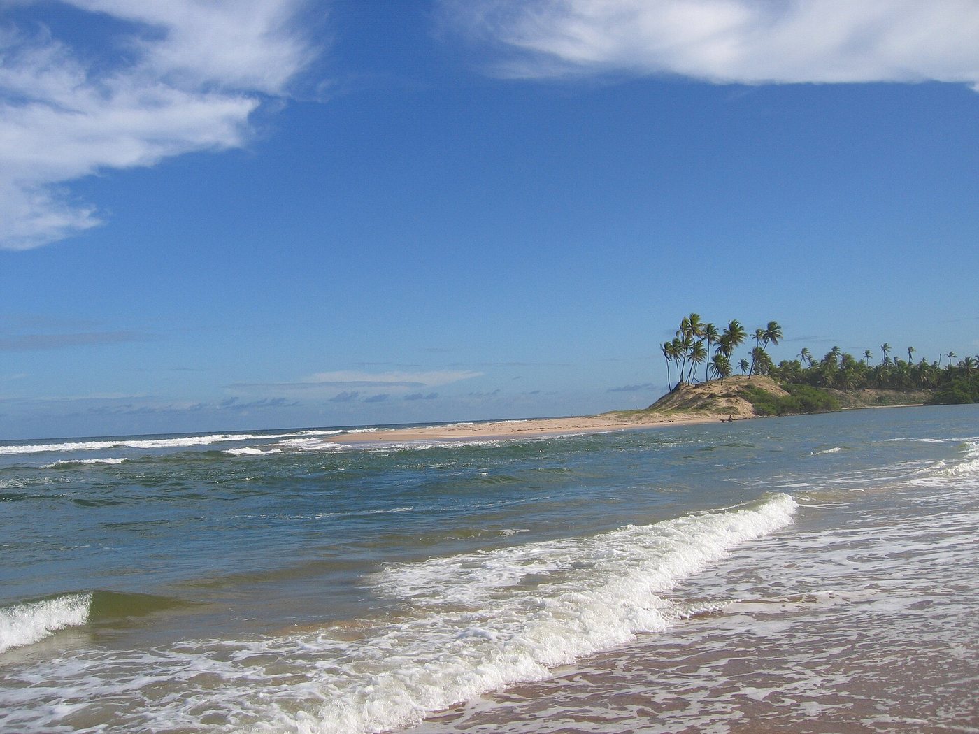 Praia com mar agitado e coqueiros ao fundo em Conde, no Litoral Norte da Bahia